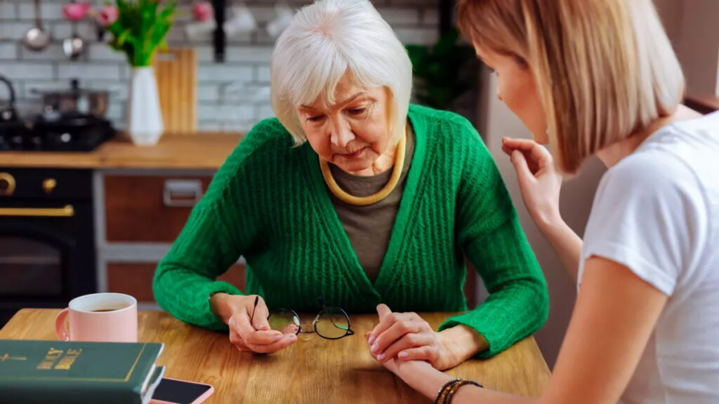 Une femme qui aide une aînée.